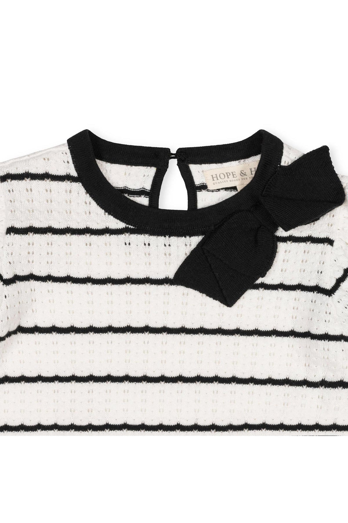Close-up of a black and white striped sweater dress featuring a soft organic cotton material.