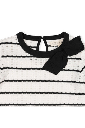 Close-up of a black and white striped sweater dress featuring a soft organic cotton material.