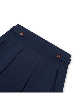 Navy blue classic ponte pleated skort featuring button tab details at the waistband, designed for toddlers and girls. The fabric offers a polished look suitable for school and everyday outings.