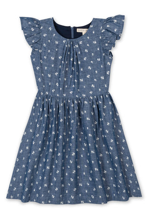 Blue chambray dress featuring delicate white floral patterns and ruffle sleeves. Made from soft organic cotton, it’s designed for toddlers and kids, perfect for everyday wear or special occasions.