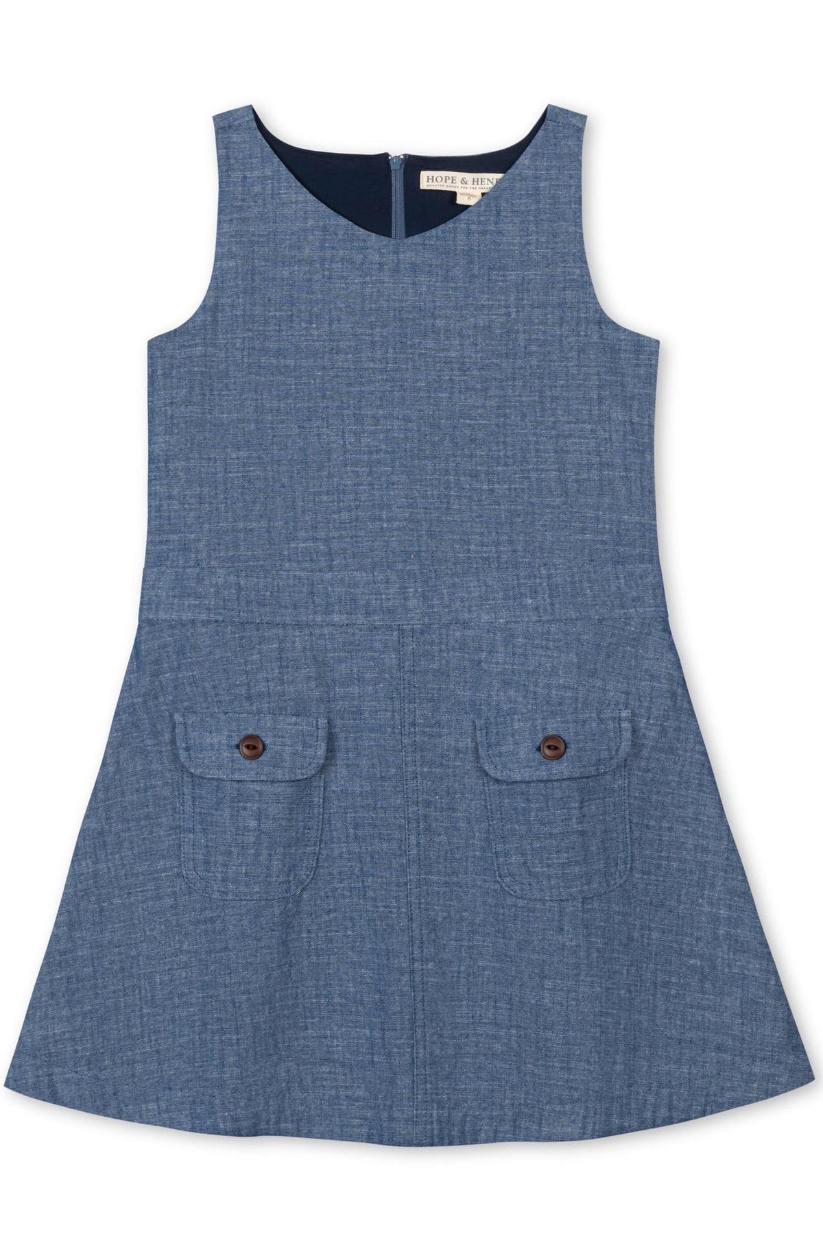 A classic chambray jumper in soft blue, featuring a V-neckline and two front pockets with wooden buttons. Made from 100% organic cotton, it’s perfect for toddlers and girls.