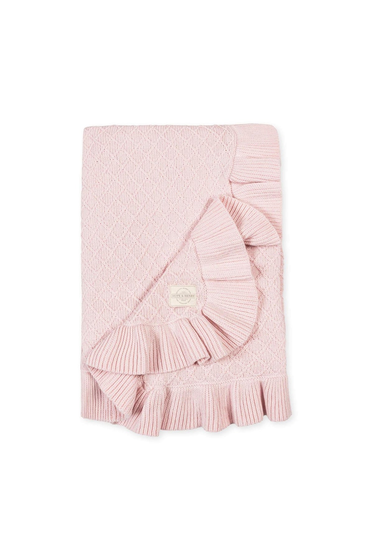 A pale pink organic cotton baby blanket features a delicate ruffle edge and textured stitch, offering a soft and cozy feel, perfect for everyday outings. Ideal for infants and toddlers.