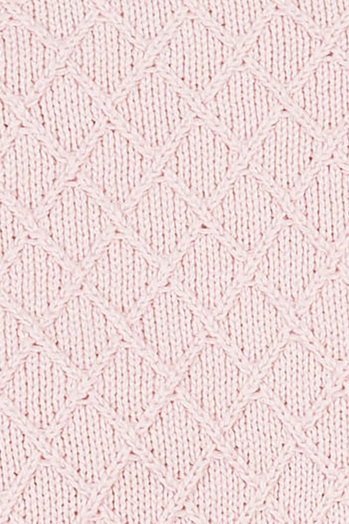 Close-up of a pale pink organic cotton blanket featuring a textured diamond stitch pattern. The soft fabric showcases its sustainable qualities, perfect for cozying up with your little one.