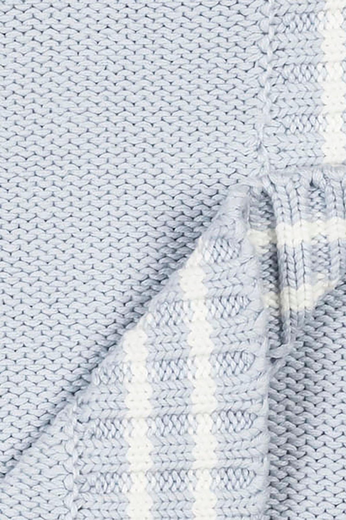 Close-up of a pale blue organic cotton cable knit baby blanket featuring a chunky purl stitch and classic white stripe trim, showcasing its soft texture and sustainable material.