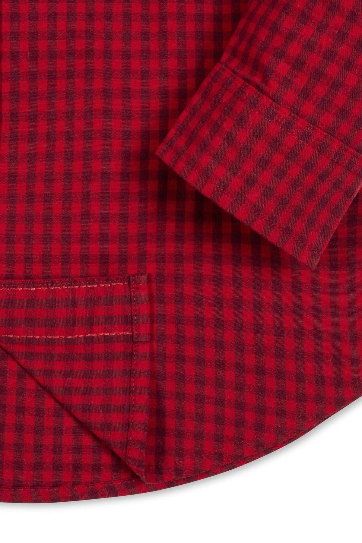 Close-up of a red gingham organic cotton poplin shirt featuring a curved hem, button details, and a label.