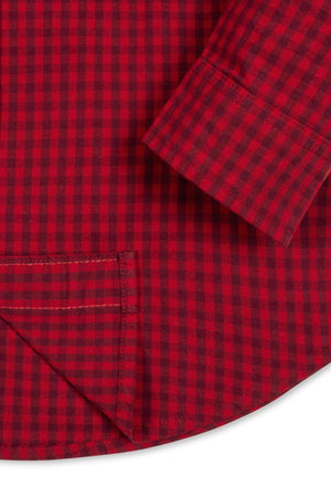 Close-up of a red gingham organic cotton poplin shirt featuring a curved hem, button details, and a label.
