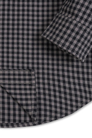Close-up view of a black gingham organic cotton stretch poplin shirt, featuring a button-down front, a functional chest pocket, and a curved hem, perfect for kids ages 2T-18.