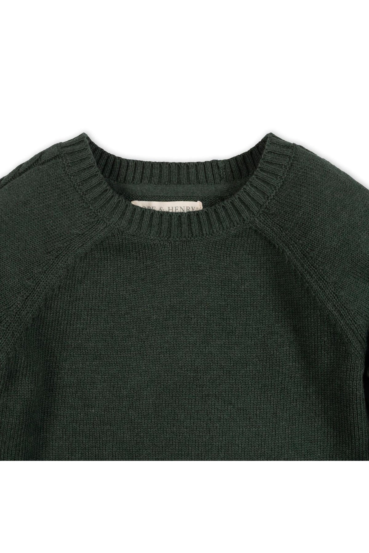 Close-up of a forest green organic cotton crew neck sweater featuring sporty raglan sleeves and ribbed trim. The fabric appears soft and cozy, suitable for children aged 2T-18.
