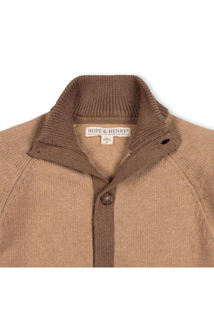 A close-up view of a camel and cinnamon mock neck cardigan made from soft organic cotton. The sweater features a button front closure and a cozy ribbed collar.