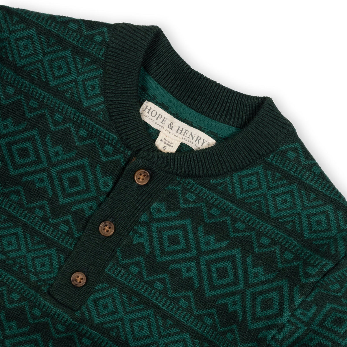 A deep green organic cotton sweater henley features a geometric pattern, ribbed collar, and matte button closure. It is made by Hope & Henry, suitable for sizes 2T-18.