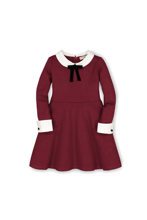 A classic oxblood dress featuring a contrast Peter Pan collar and cuffs, embellished with a black bow at the neckline.