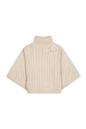 Light oatmeal organic cotton turtleneck cape featuring a cozy rib knit design and a bow detail at the neck. This sustainable garment is perfect for toddlers and girls.