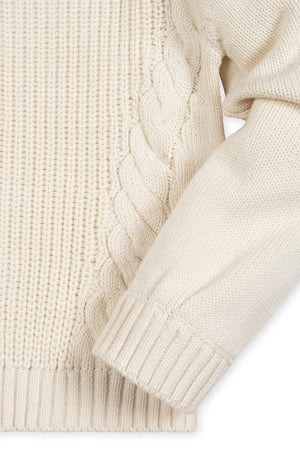 Ivory organic cotton sweater featuring a mix of cable and rib knit patterns. Designed for toddlers and girls, it showcases feminine bubble sleeves and a cozy crew neckline.