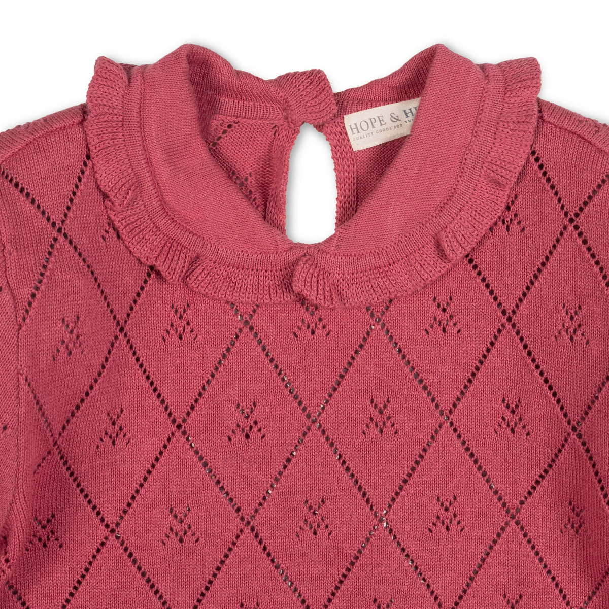 Close-up of a rosewood-colored organic cotton sweater featuring a delicate diamond pattern, a ruffled Peter Pan collar, and a keyhole closure at the back neck for easy dressing.