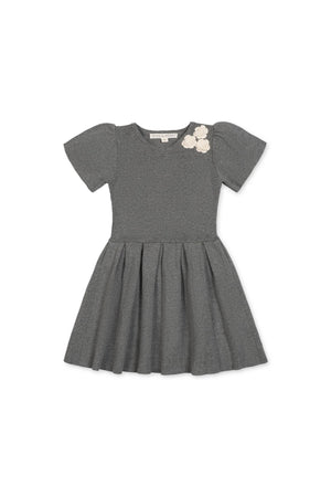 A dark gray organic cotton pleated sweater dress features short puff sleeves and decorative rosettes at the neckline, perfect for toddlers and girls who love to twirl in comfort.