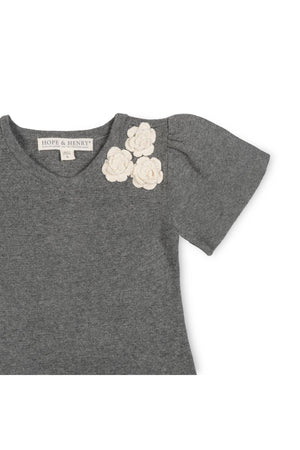 Close-up of a dark gray sweater featuring soft organic cotton fabric. The dress has decorative rosettes at the neckline, adding a charming detail suitable for toddlers and girls.