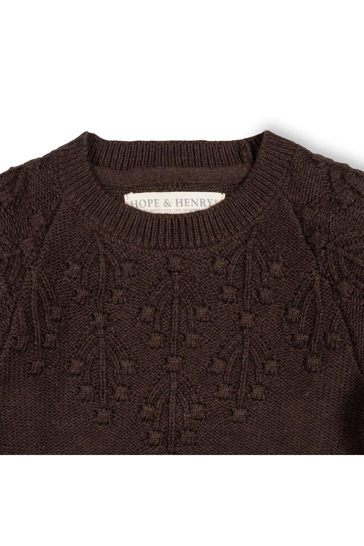 Close-up of a chocolate heather organic cotton sweater featuring a decorative stitch pattern on the shoulders. The label reads Hope & Henry, highlighting its sustainable attributes for toddlers and girls.