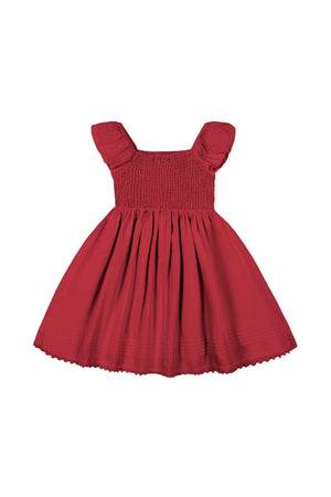 A vibrant red flower girl dress featuring a stretchy smocked bodice and gently puffed sleeves, made from soft organic cotton sateen, perfect for special occasions and twirling.