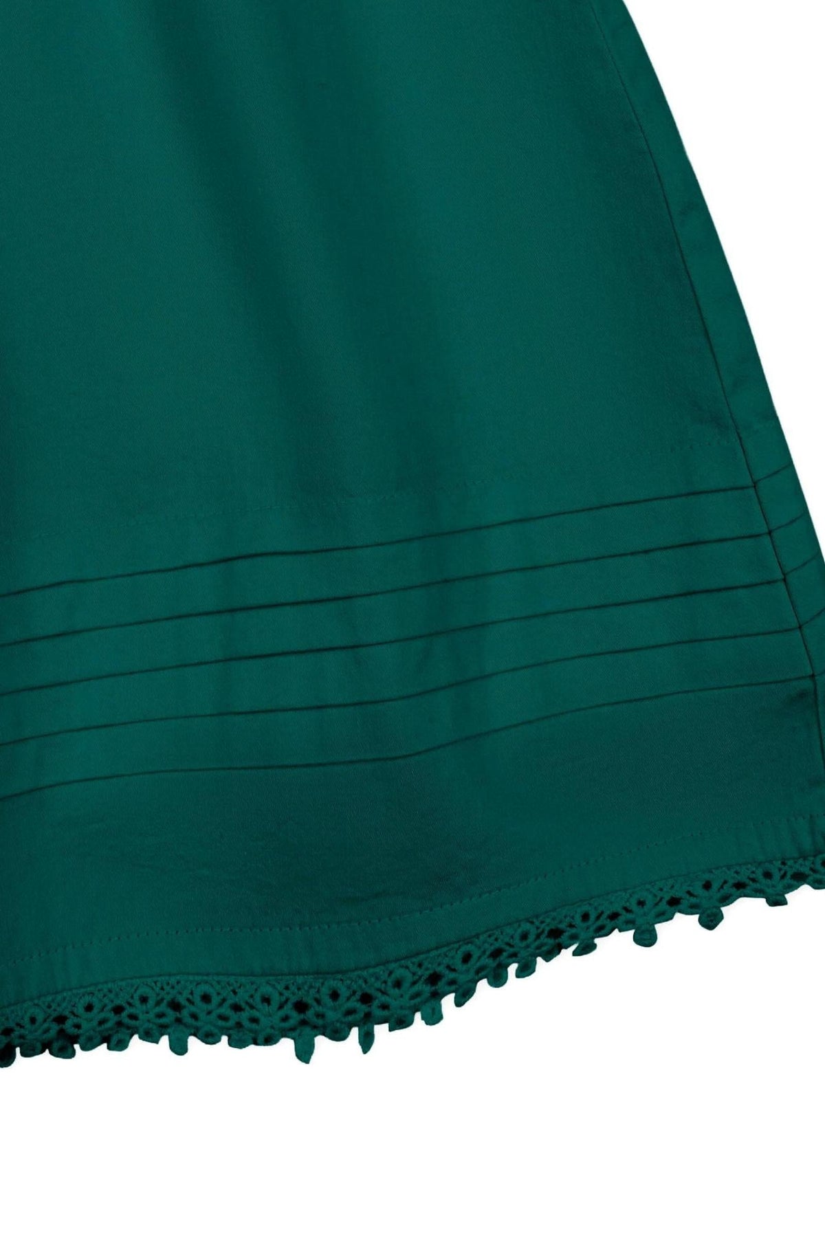 The image showcases a deep green organic cotton sateen dress hem featuring pintucked detailing and a delicate crochet trim. This elegant design is perfect for special occasions.