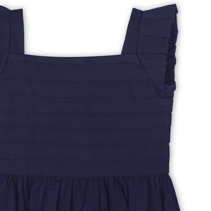 Close-up of a navy organic cotton dress showcasing a pleated bodice and knife-pleated cap sleeves. The soft fabric is perfect for special occasions and comfortable for toddlers.