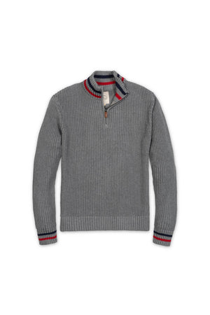 A dark gray organic cotton half-zip pullover features a rib knit mock neck and contrasting red and navy stripes at the collar and cuffs. Ideal for layering in cool weather.
