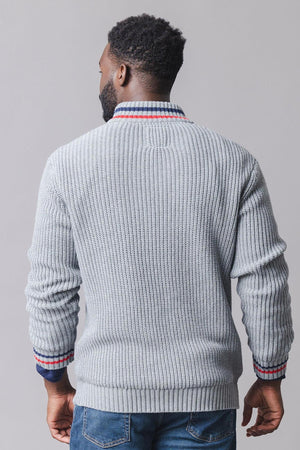A man is seen from the back, wearing a light gray, ribbed knit sweater with a striped collar. The half-zip design features a comfortable fit, suitable for layering.