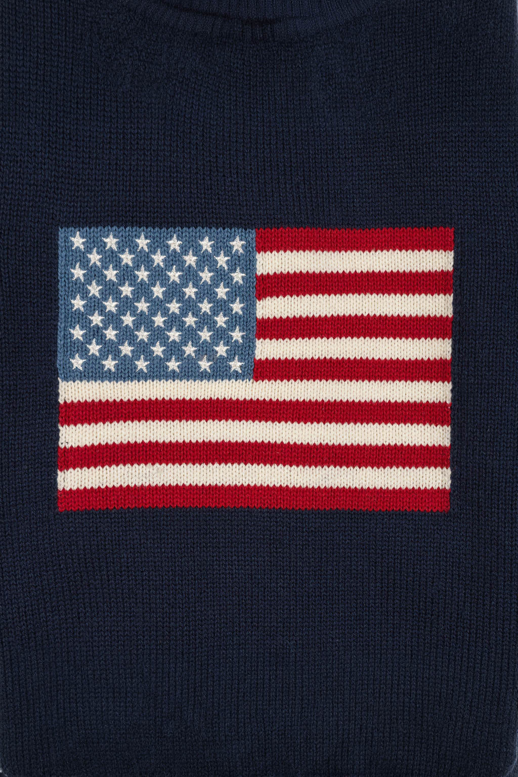 Close-up of a navy blue sweater featuring an American flag intarsia design with embroidered stars. Made from soft, organic cotton, it’s perfect for family gatherings and everyday wear.