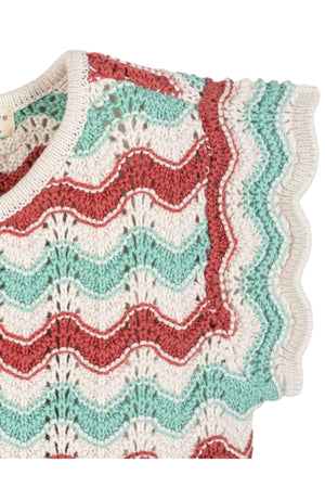 Close-up of a lightweight organic cotton sweater top featuring wavy red and teal stripes, delicate flutter sleeves, and a textured knit. Ideal for warm weather, suitable for children ages 2T-12.