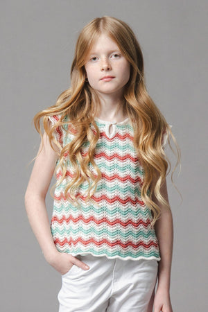 A young girl models a lightweight, organic cotton sweater top featuring wavy edged flutter sleeves in a colorful zigzag pattern.