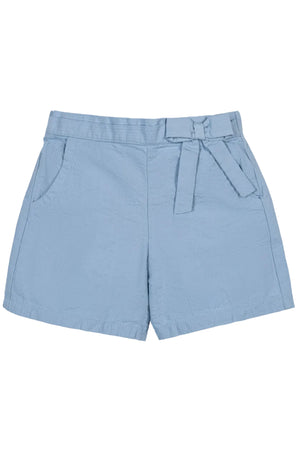 Light blue organic cotton seersucker shorts feature a faux belt and decorative bow, designed for comfort and style during warm weather play. Suitable for children aged 2T-12.