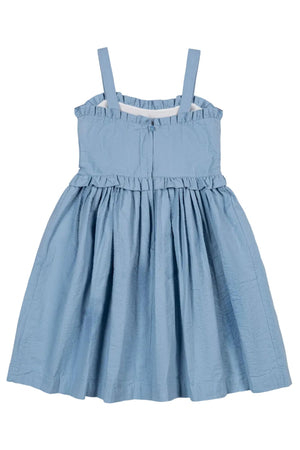 Light blue organic cotton seersucker dress featuring ruffle edges and adjustable straps. This feminine dress is perfect for summer adventures and is suitable for girls aged 2T to 12.