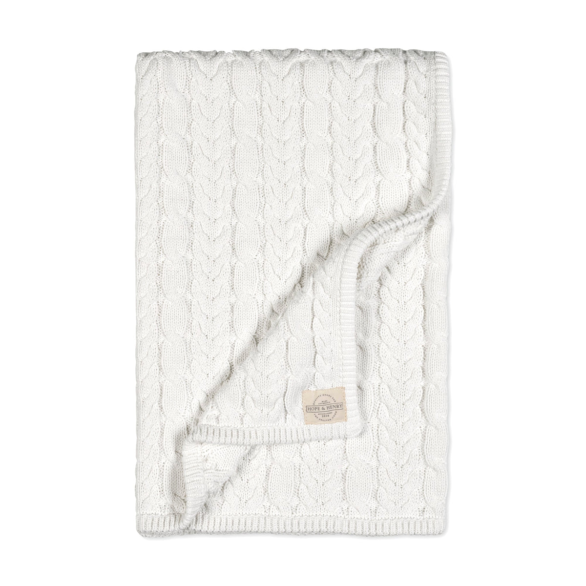 A soft, cream-colored knitted blanket featuring a textured cable pattern. This cozy blanket is perfect for infants, made from organic materials for gentle comfort against delicate skin.