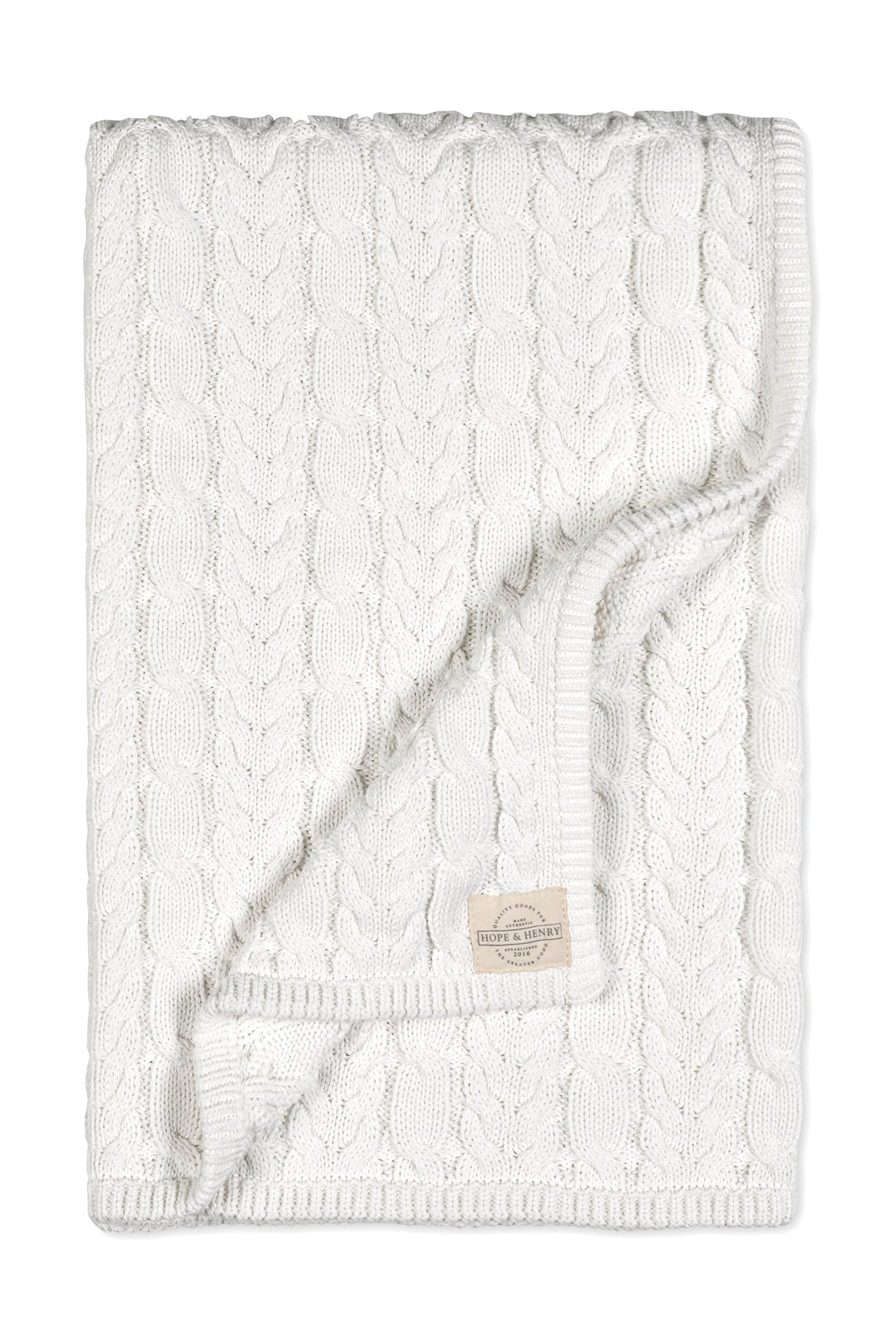 A soft white organic cotton cable knit baby blanket features a chunky pattern, perfect for strollers and outings. This heirloom-quality piece is ideal for gifting or personal use.