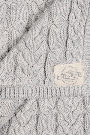 Light gray organic cotton cable knit blanket featuring a textured design. The blanket is branded with a Hope & Henry label, showcasing its soft, eco-friendly material and timeless style.