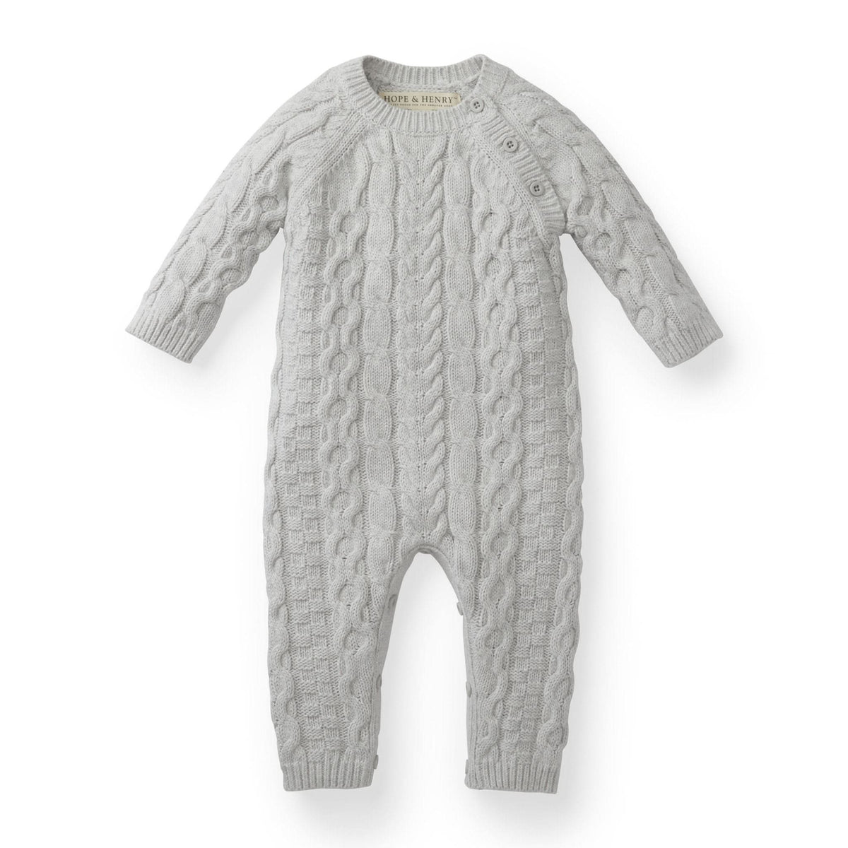 Light gray cable knit romper featuring long sleeves and button details, made from GOTS certified organic cotton for baby’s comfort. Ideal for dressing little ones in a cozy, stylish way.