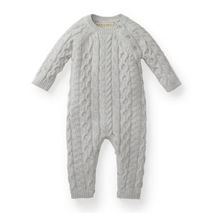 Light gray cable knit romper featuring long sleeves and button details, made from GOTS certified organic cotton for baby’s comfort. Ideal for dressing little ones in a cozy, stylish way.