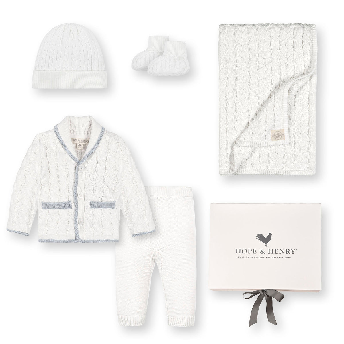 A cozy five-piece baby gift set by Hope & Henry features a classic cable knit design in snow white, including a cardigan, pants, hat, booties, and a blanket, all made.