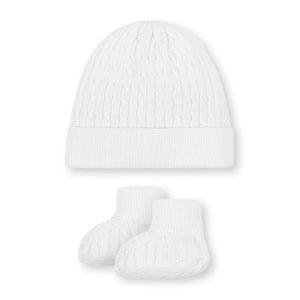 A white cable knit baby hat and matching booties made from soft, GOTS certified organic cotton. This cozy set is perfect for keeping little ones warm and comfortable.