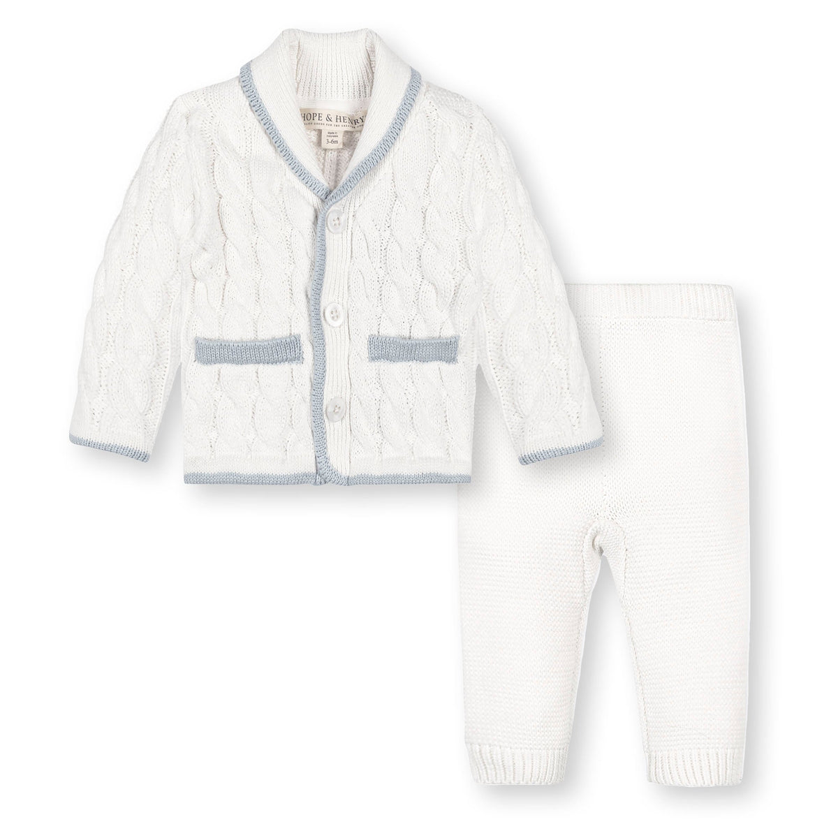 A cozy, snow white baby cardigan and matching pants made from soft, GOTS certified organic cotton. The classic cable knit design features blue trim, perfect for keeping little ones comfortable.