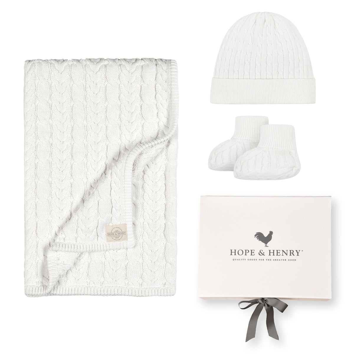 A cozy snow white cable knit blanket, matching beanie, and booties are displayed alongside a beautifully packaged gift box labeled Hope & Henry.