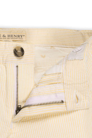 Close-up view of Hope & Henry organic cotton seersucker shorts for boys, featuring a yellow and white striped pattern.