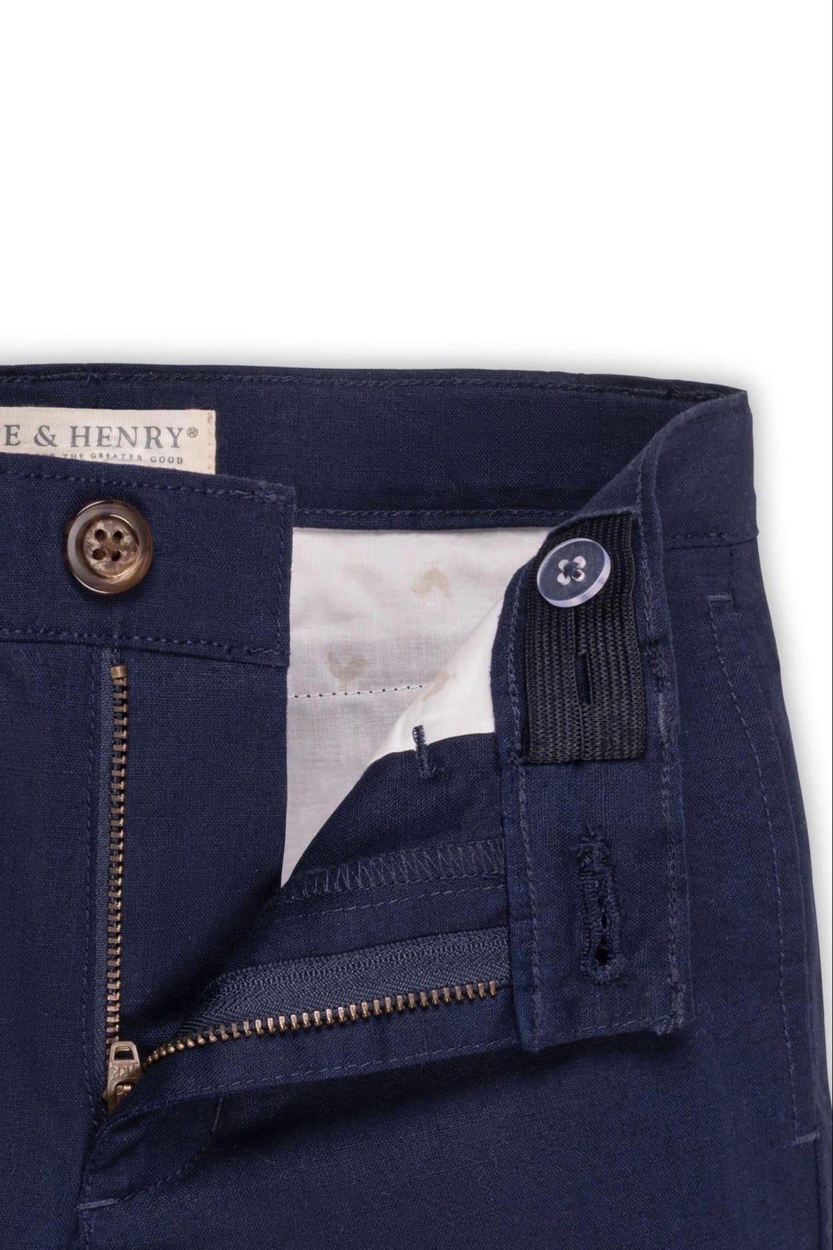 Navy linen suit pants with a zip fly and faux tortoiseshell button closure, showing adjustable waistband detail.