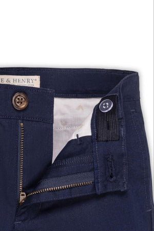 Navy linen suit pants with a zip fly and faux tortoiseshell button closure, showing adjustable waistband detail.