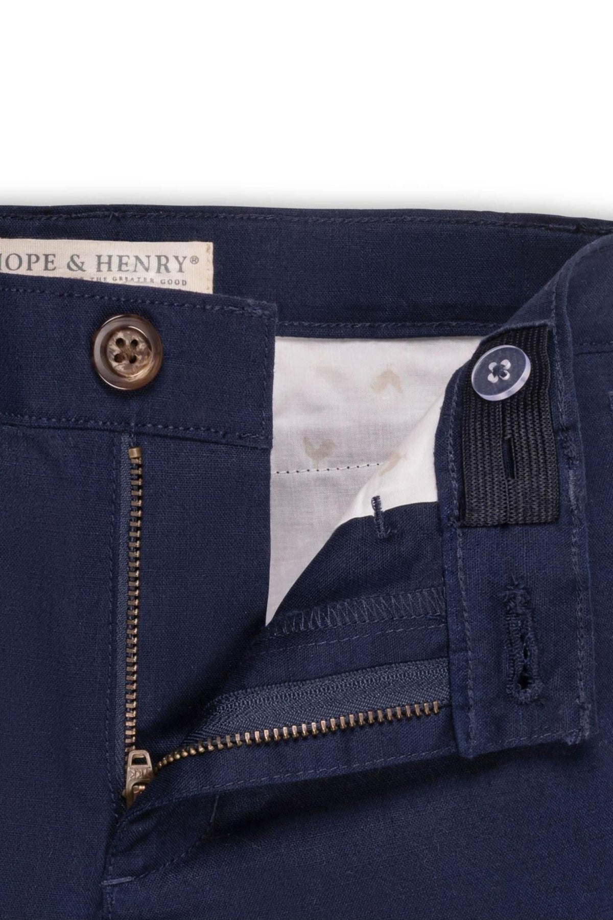 Close-up view of Hope & Henrys navy linen suit pant for baby boys, featuring a zip fly, faux tortoiseshell button, and adjustable waistband, showcasing its quality and style.