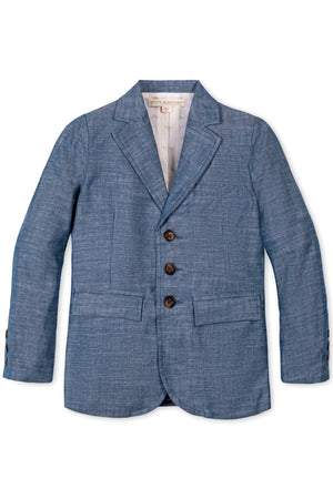Blue chambray suit jacket for boys with faux horn buttons and flap pockets, made from organic cotton.