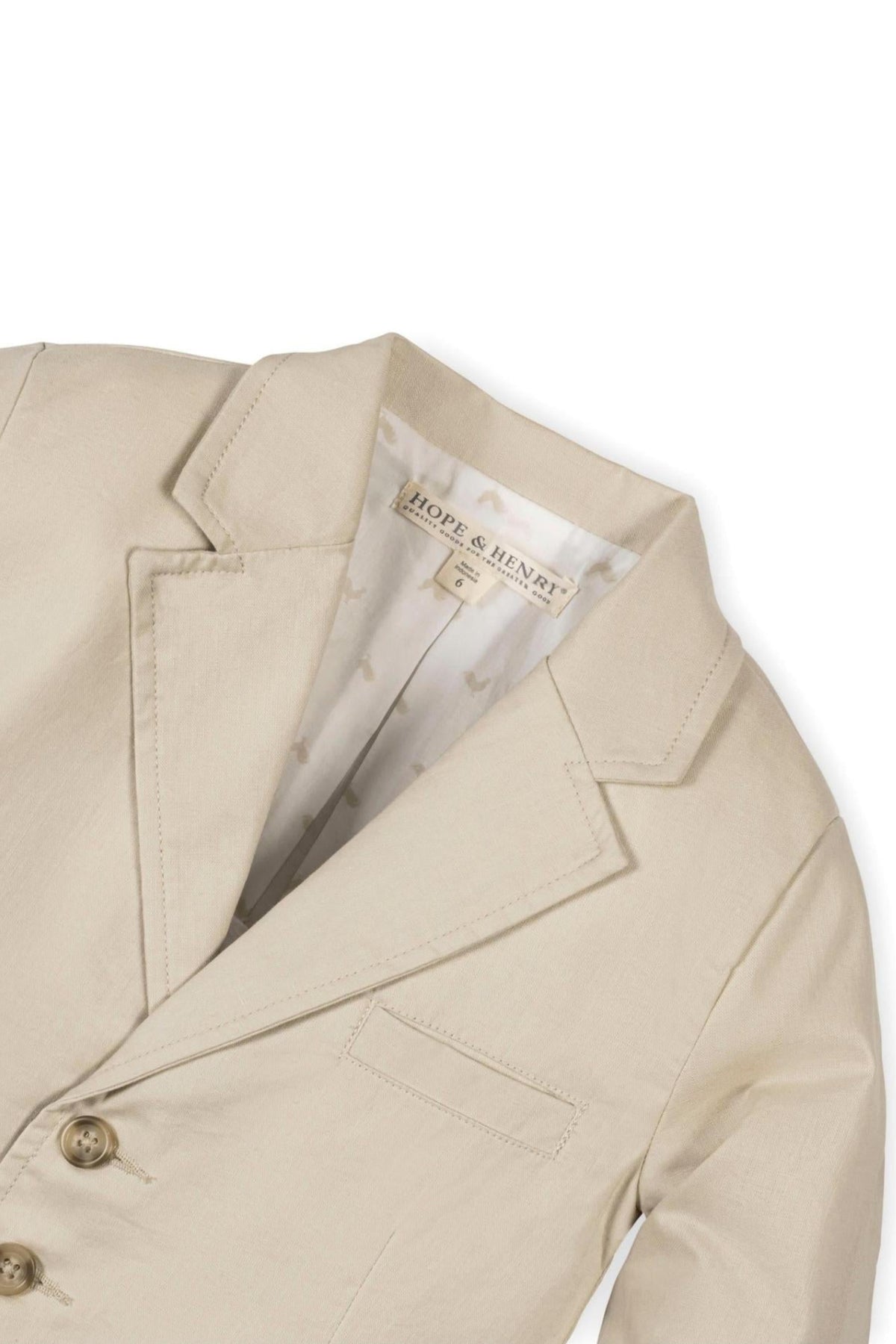Beige linen suit jacket by Hope & Henry, featuring a notch collar, faux tortoiseshell buttons, and a fully lined interior. Designed for boys, sizes 2T-12, combining classic style with comfort.