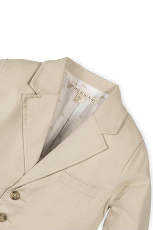 Beige linen suit jacket by Hope & Henry, featuring a notch collar, faux tortoiseshell buttons, and a fully lined interior. Designed for boys, sizes 2T-12, combining classic style with comfort.