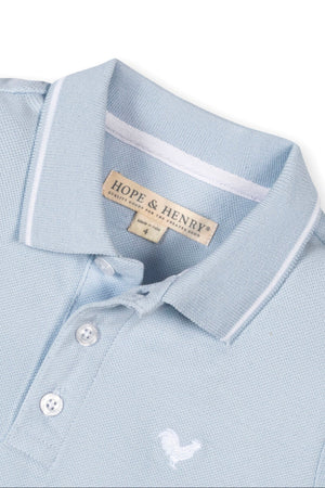 Close-up of a light blue organic cotton polo shirt by Hope & Henry, featuring a flat-knit collar and button placket.