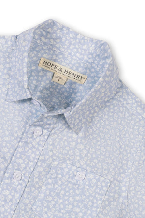 Light blue short sleeve shirt by Hope & Henry featuring a subtle floral pattern, button-down collar, and a functional chest pocket. Made from breathable fabric, perfect for warm weather.