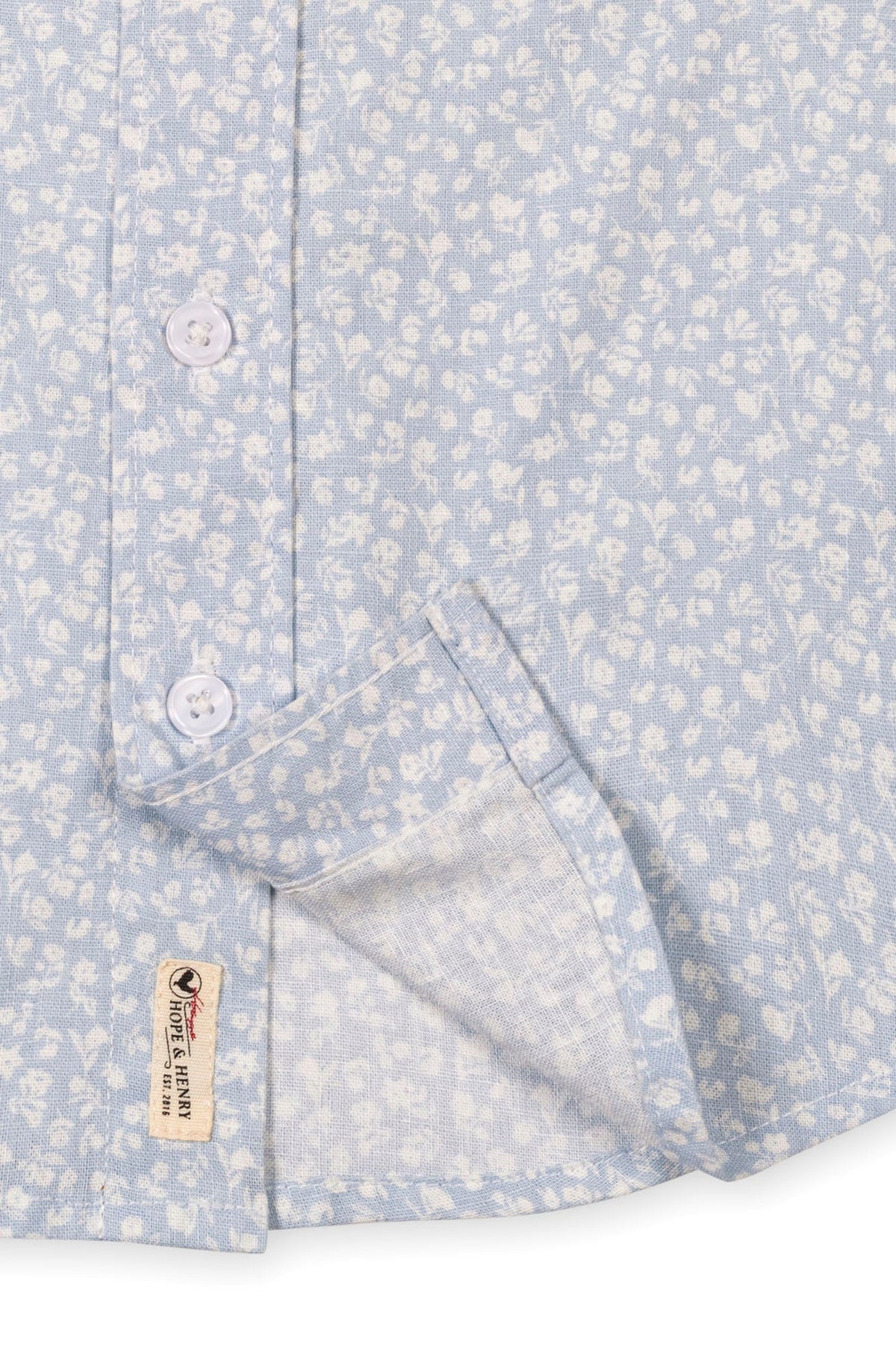 Light blue short sleeve shirt featuring a subtle floral pattern, button closure, and a functional chest pocket.